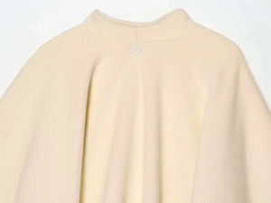 Close-up of the semi-high collar and single back button on the cream fleece coat