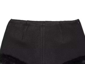 Dettaglio dei pantaloncini neri a vita alta con cerniera laterale e bordo in pelliccia