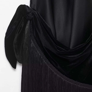 Elegant black velvet bow and pleated fabric detail on a stylish summer dress