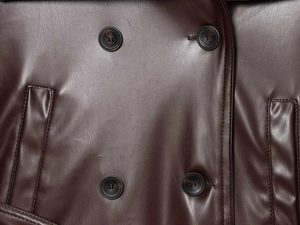 Détail des boutons à double boutonnage et de la texture sur la veste en cuir marron foncé