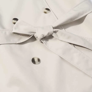 Fashionable beige double-breasted trench coat with waist belt and tortoise buttons
