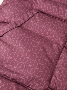Gros plan du motif géométrique sur le tissu matelassé d'une veste en coton à capuche