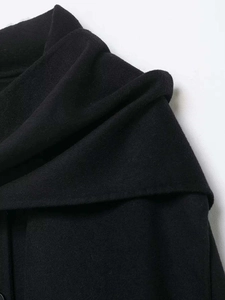 Macro detail of high-quality black wool coat showing wide lapel collar and textile texture