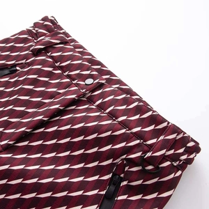 Détail du pantalon de ski texturé bordeaux avec taille boutonnée et anneau métallique