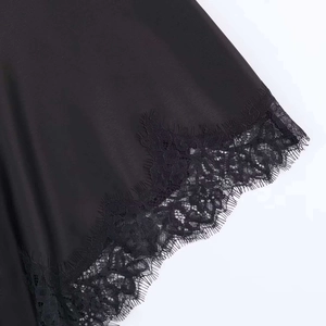 Detailed close-up of glossy satin fabric with elegant black eyelash lace trim detail
