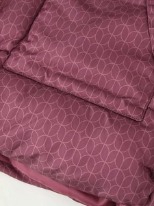 Gros plan d'une veste matelassée violet foncé avec motifs floraux et texture douce