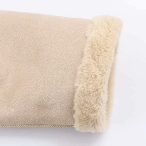 Detailopname van beige faux suède manchet met dikke imitatiebontvoering en stikselwerk