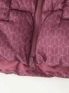 Détail de la veste rembourrée rouge agate avec motif de feuilles et fermeture éclair en résine