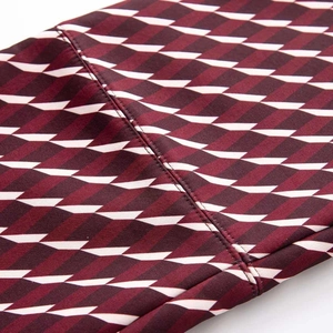 Gros plan du tissu de combinaison de ski bordeaux texturé avec doubles coutures renforcées