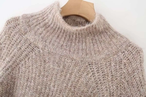 Close-up of oatmeal knit sweater featuring ribbed mock neck and soft mohair texture