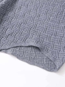 Detailed macro view showing the basket-weave knit texture of the grey sweater hemline