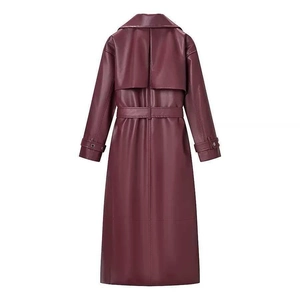 Detail view of burgundy long leather coat back featuring storm flap and belted waist