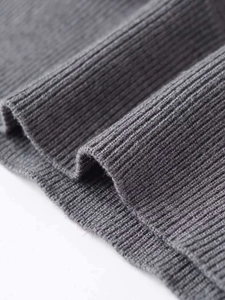 Detailed close-up of grey ribbed knit fabric texture showing vertical weave patterns