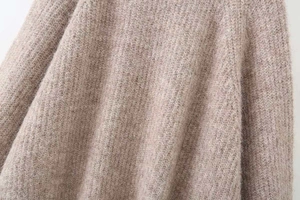 Close-up of oatmeal colored knit sweater showing soft brushed texture and hairy fibers