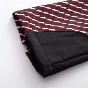 Détail du motif à losanges géométriques et couture noire sur la manche du blouson de ski