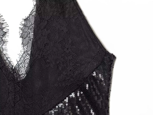 Gros plan sur la dentelle florale noire avec bordure cil et texture en paillettes