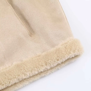 Detail van imitatiebont en gebreide stof op de zoom van een beige winterjas