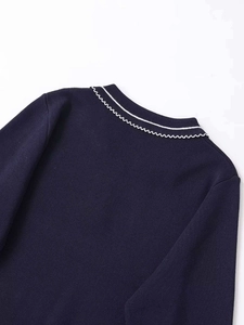 Close-up of contrast wavy scalloped collar and fine navy blue knit texture on sweater