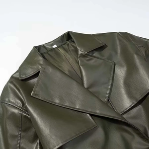 Detailed macro view of the dark green faux leather lapel and texture on a long coat