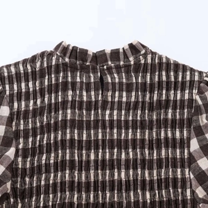 Detail of vintage plaid blouse with smocking texture and ruffled collar neck