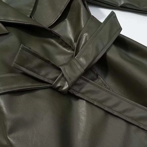 Close-up of olive green PU leather coat waist belt and textured fabric details