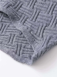 Close-up of grey geometric jacquard knit fabric showing thick texture and weave pattern