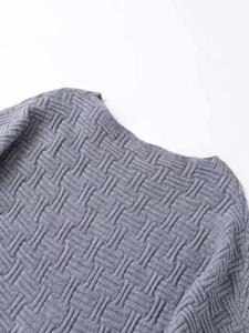 Macro shot of grey basketweave knit texture and clean neckline stitching details
