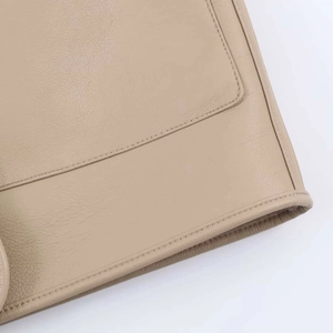 Detail view of premium beige leather texture and reinforced double stitching on the jacket