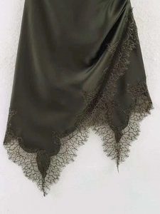 Gros plan sur la robe en satin vert foncé avec dentelle et ourlet asymétrique élégant