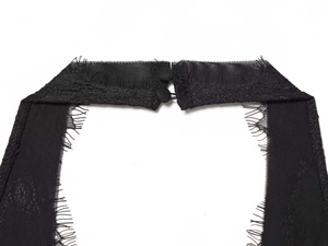 Détail du col licou noir avec bordure en dentelle cils et fermeture à deux boutons