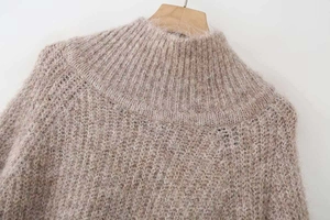 Macro detail of oatmeal knit sweater showing rib neckline and soft mohair texture
