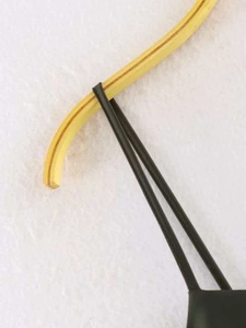 Détail des fines bretelles noires et coutures en dentelle sur une robe d'été minimaliste