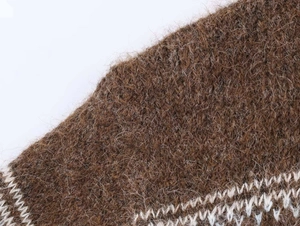 Detail of vintage jacquard knit sweater featuring brown fuzzy mohair fabric with white patterns
