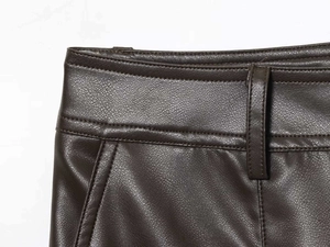 Détails macro du pantalon en simili cuir marron foncé avec passants et poches latérales