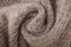 Close-up of oatmeal knitted fabric showing soft long-fiber mohair texture and premium weave