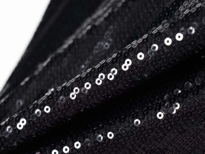 Détails macro de paillettes noires de haute qualité sur une robe courte dos nu scintillante