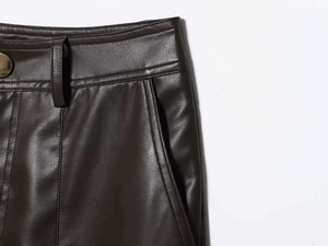 Détail de la taille en similicuir marron foncé avec passants de ceinture et bouton