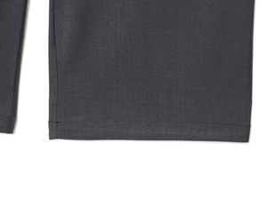 Close-up of the dark grey straight-leg trousers showing fine twill fabric and neat stitching