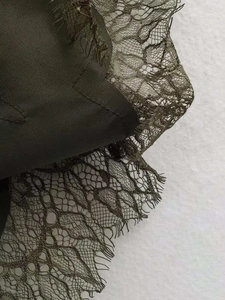 Gros plan sur la dentelle délicate et la texture de la robe vert foncé