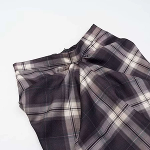 Detail of plaid skirt waist showing invisible zipper and pleated texture in grey check