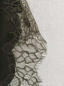 Détail de la dentelle fine sur le bord de la robe d'été vert olive à bretelles