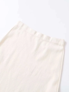 Detailed macro view of the wide elastic waistband on this beige knitted lace midi skirt