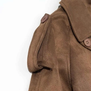 Detail shot of shoulder epaulette and button on brown faux suede trench coat