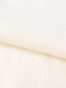 Detailed macro shot of premium cream knitted fabric texture with fine rib-knit design