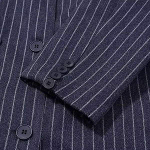 Detail of dark blue striped wool coat showing cuff buttons and fine fabric texture