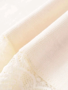 Detailed close-up showing the elegant lace trim and ribbed knit texture of the beige skirt