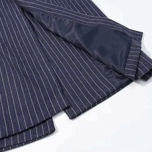 Close-up of navy striped wool coat hem featuring fine white pinstripes and smooth inner lining