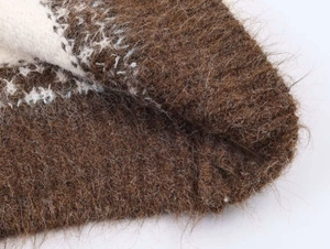 Close-up of vintage jacquard pattern on fluffy mohair knit cardigan sweater fabric