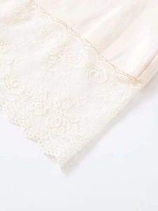 Detailed macro view of delicate lace trim and ribbed texture on the beige midi skirt