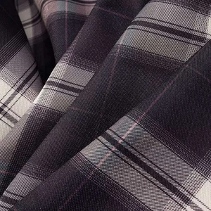 Detail shot of brown and beige plaid fabric with high-quality woven texture and pleats